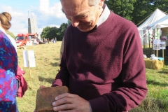Ian Symes, Parish Council Vice Chairman, examining a brick made on the Common